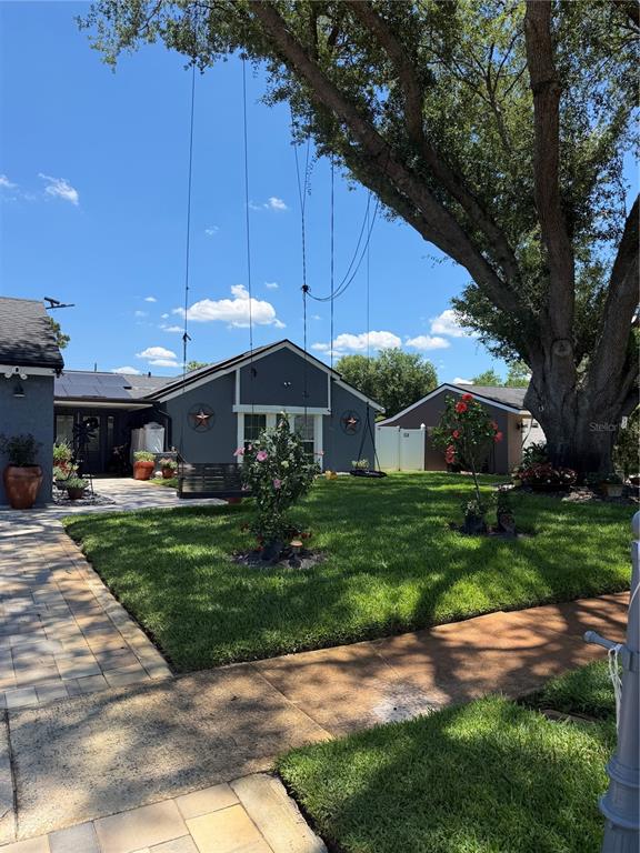 A front yard features a large tree, a hanging swing, and a gray house — 1409 PONCE DE LEON BOULEVARD, WINTER SPRINGS, FL