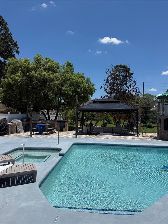 A backyard features a swimming pool with a spa, a gazebo, and a patio area — 1409 PONCE DE LEON BOULEVARD, WINTER SPRINGS, FL