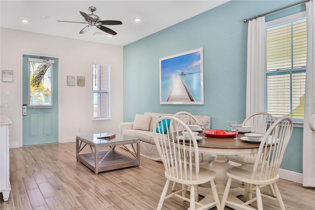 A living and dining area features light wood floors, a blue accent wall, and furniture — 8038 SURF STREET, KISSIMMEE, FL