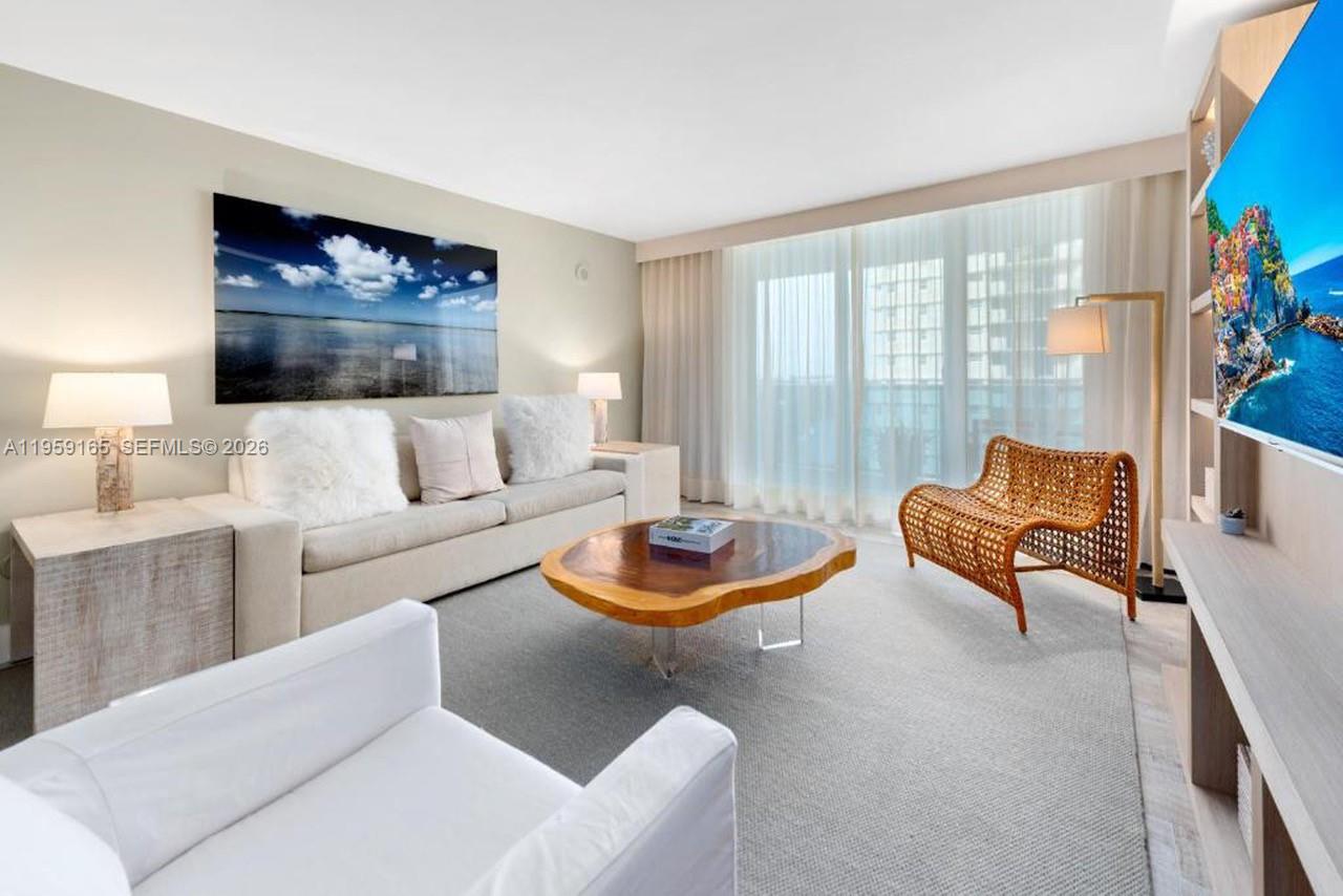 A bathroom features a vessel sink, a glass-enclosed shower, and beige stone tile throughout — 102 24th St # 1007, Miami Beach FL 33139, MIAMI BEACH, FL