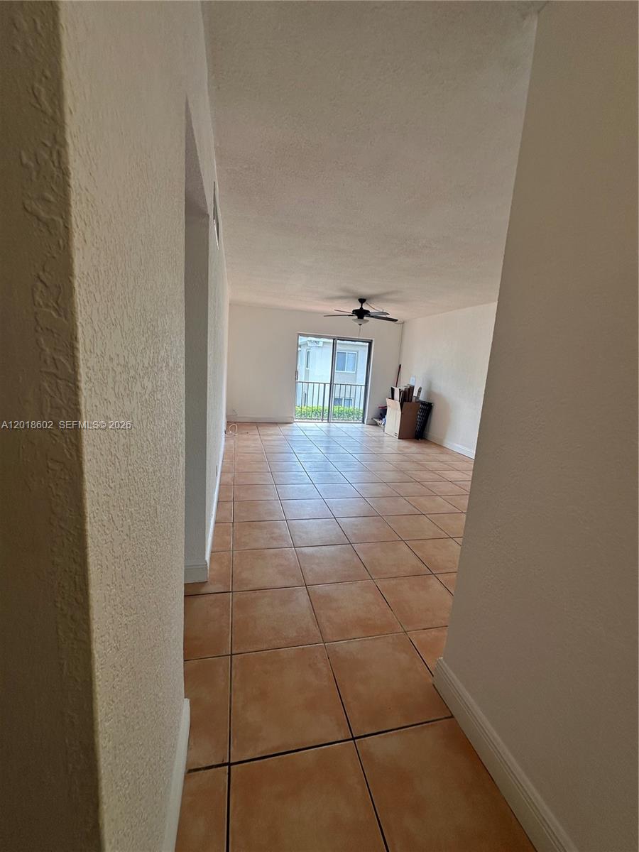 A view through a doorway into a living area with tiled floors and a balcony — 6713 N Kendall Dr # 611, Pinecrest FL 33156, PINECREST, FL