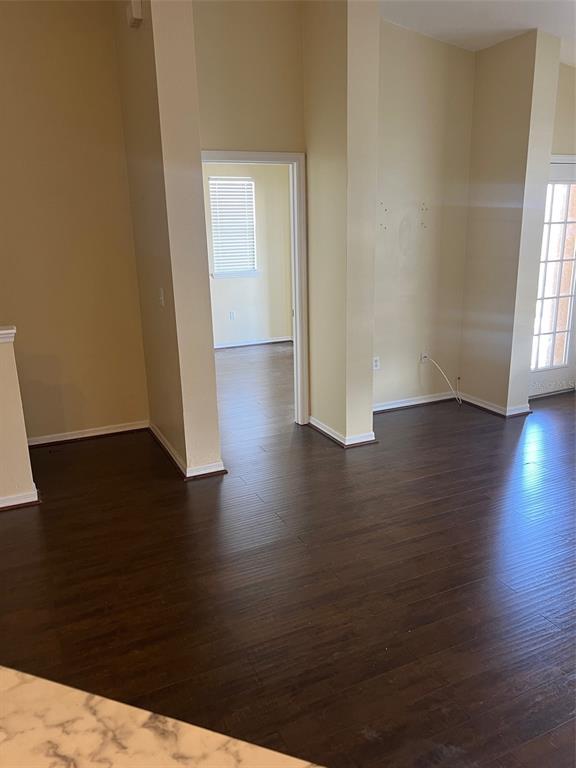A room with dark wood flooring and a doorway leading to another room with blinds — 9122 MOONLIT MEADOWS LOOP UNIT 1, RIVERVIEW, FL