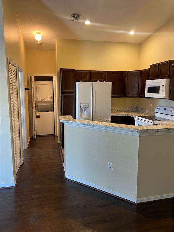 A kitchen with dark wood cabinets, white appliances, and a marble-patterned countertop peninsula — 9122 MOONLIT MEADOWS LOOP UNIT 1, RIVERVIEW, FL