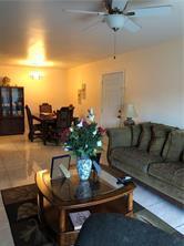 A living room with a ceiling fan, tile floors, a coffee table, and a dining area — LAUDERHILL, FL