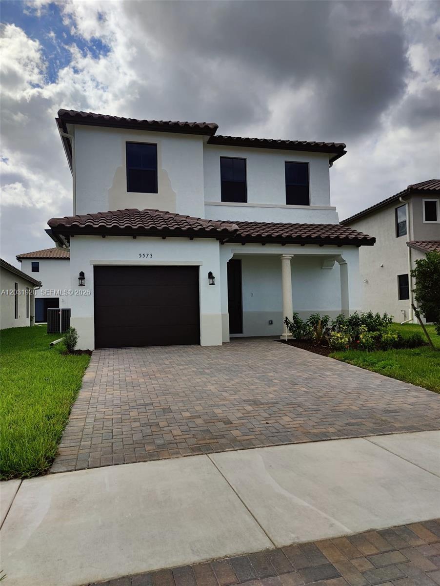 A two-story house features a brown garage door, a tiled roof, and a paved driveway — 5573 Cobalto Way # 5573, Ave Maria FL 34142, AVE MARIA, FL