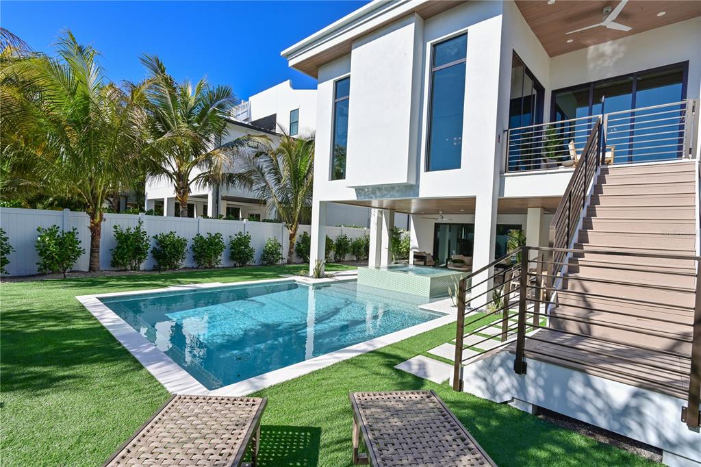 A modern house features a backyard swimming pool, a hot tub, and an outdoor staircase — 111 PALMETTO AVENUE, ANNA MARIA, FL