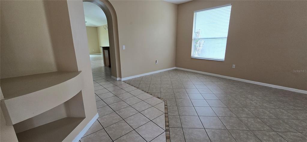 A room with beige walls, tile flooring, and a built-in arched wall niche — 2227 OAKINGTON STREET, WINTER GARDEN, FL