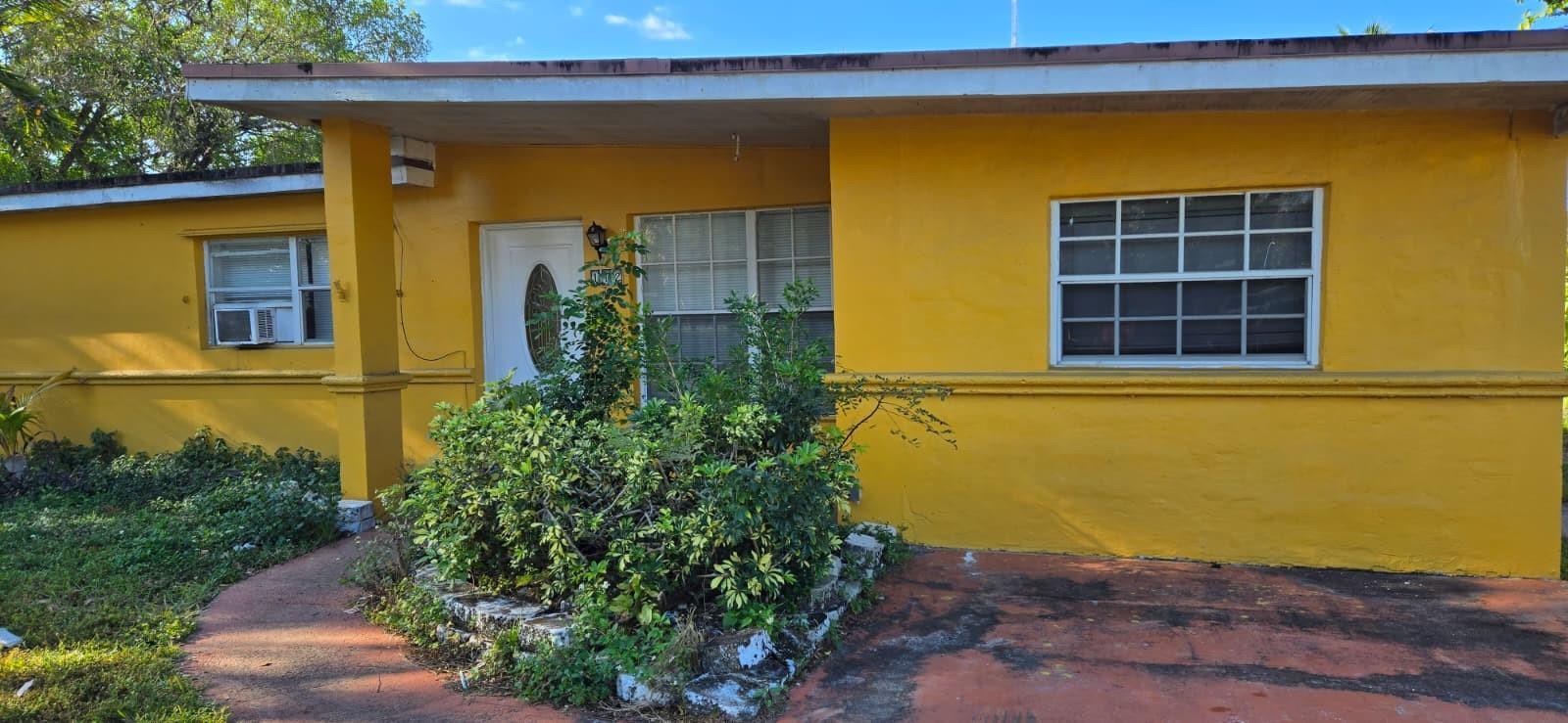 A single-story yellow house with a flat roof, a front porch, and a paved driveway — 112 Newton Road, West Park FL 33023, WEST PARK, FL