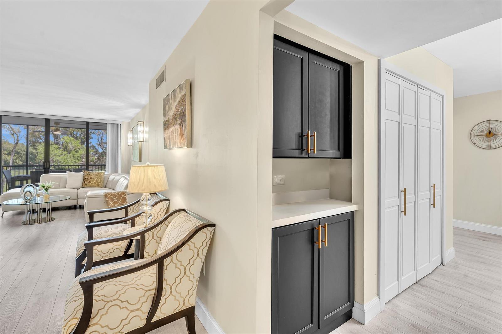 A living area features two patterned armchairs, a built-in dark cabinet, and a white closet — 2804 N 46th Avenue # C330, Hollywood FL 33021, HOLLYWOOD, FL