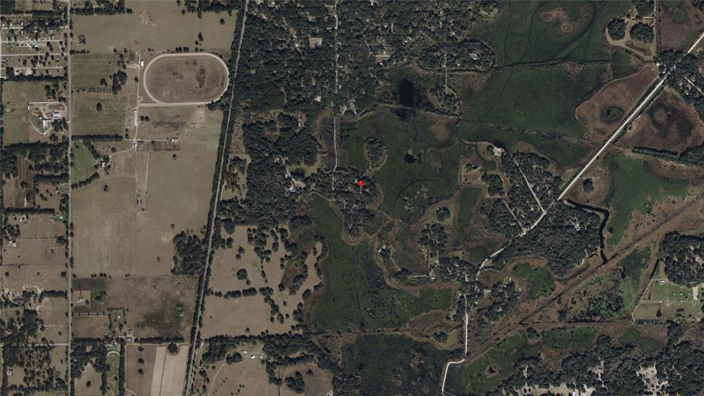 This is an aerial map view showing a property marked with a red pin — NE 155TH LANE, CITRA, FL
