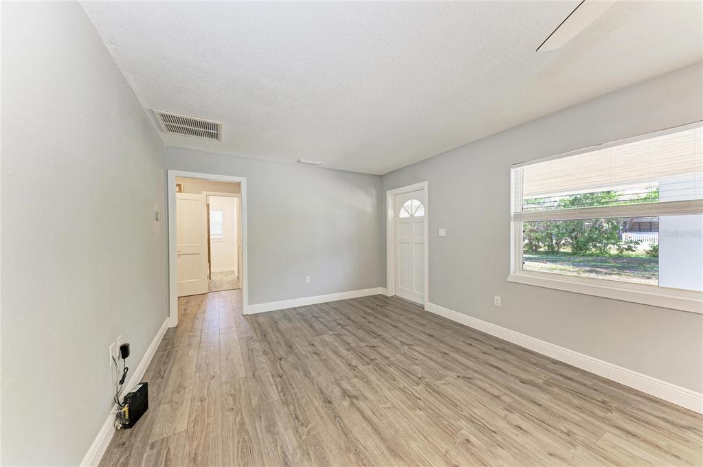 A room with light gray walls, wood-look flooring, a window, and a doorway to another room — 2401 10TH STREET W, PALMETTO, FL