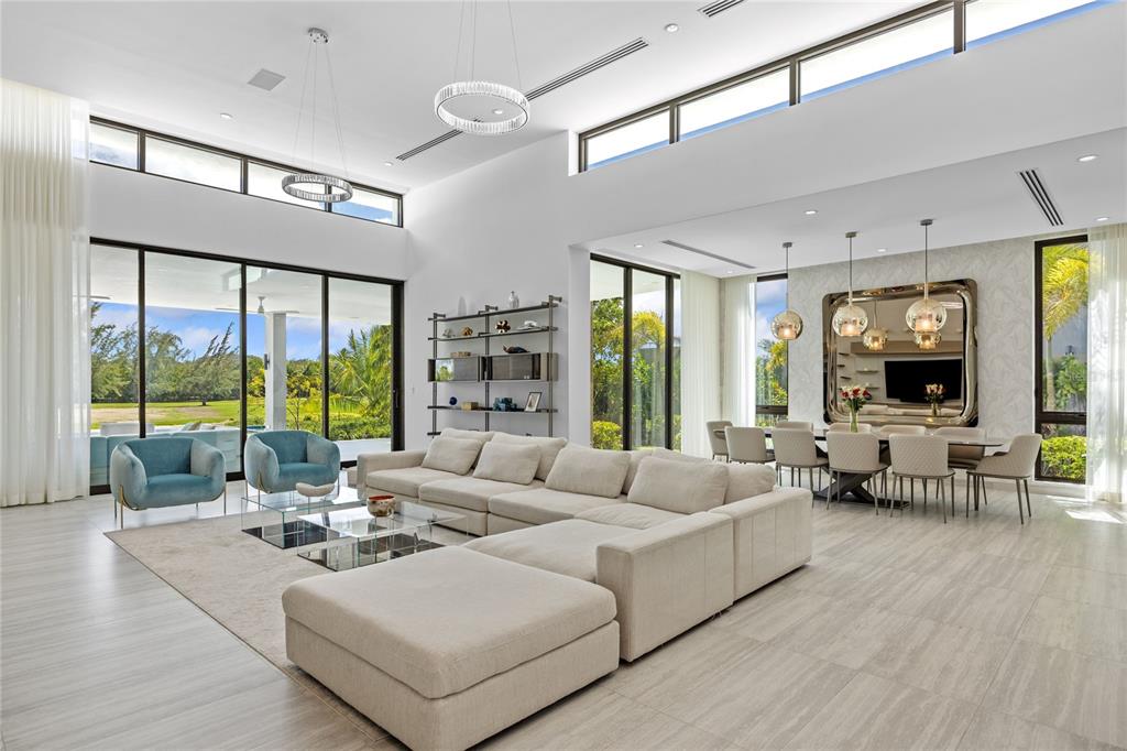A spacious, modern open-concept living and dining area with high ceilings and floor-to-ceiling windows — 13 SALT LANE, THE ISLES AT DORADO BEACH, DORADO, PR