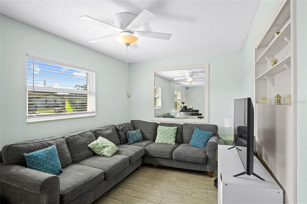 A room with light blue walls, wood-look tile flooring, a ceiling fan, and a keyboard — 7924 PLUNKETT AVENUE, ORLANDO, FL