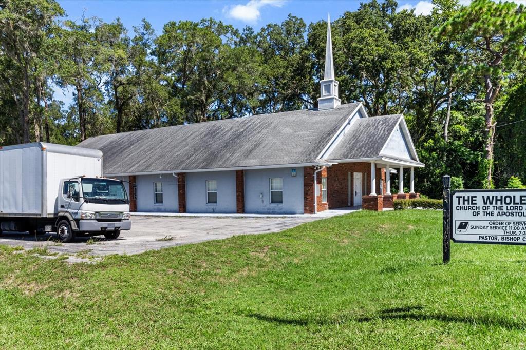 A church building with a steeple and a box truck parked on a paved lot — 1601 NW 14TH STREET, OCALA, FL