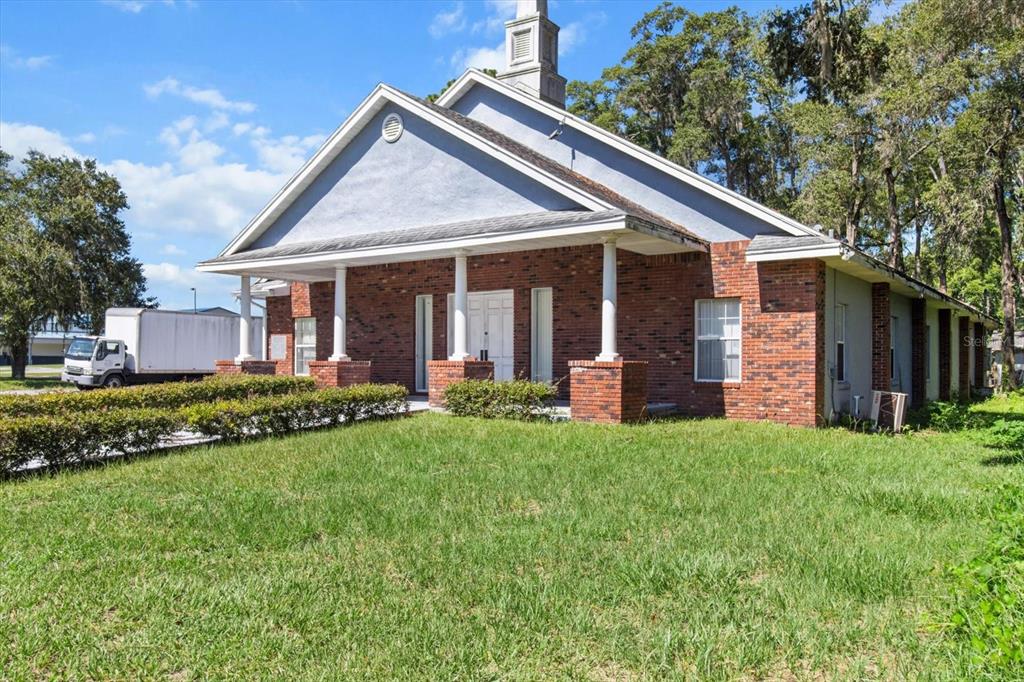 A brick church building with a white steeple and a covered front porch with columns — 1601 NW 14TH STREET, OCALA, FL