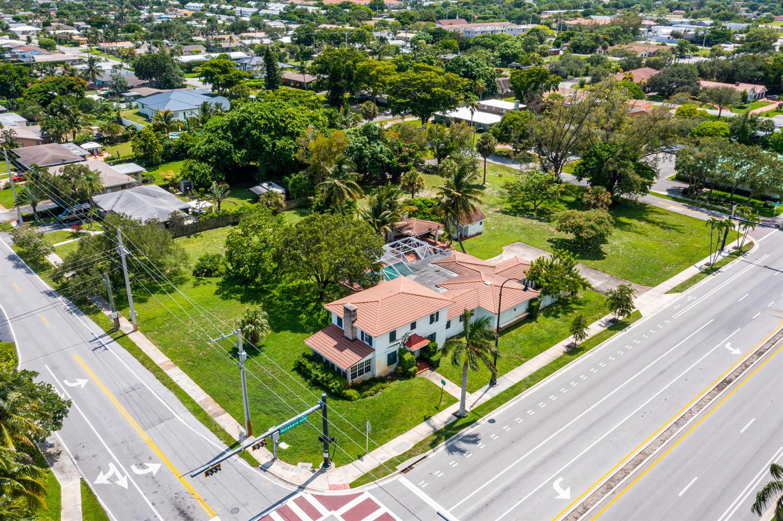 An aerial view shows a two-story house with a tiled roof and a swimming pool — 556 E Hillsboro Boulevard, Deerfield Beach FL 33441, DEERFIELD BEACH, FL