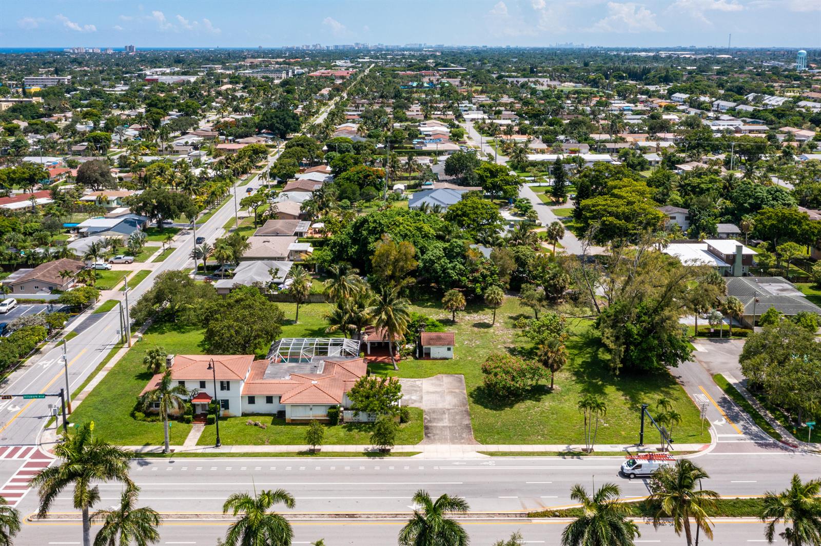 An aerial view shows a house with a tiled roof and pool on a large lot — 556 E Hillsboro Boulevard, Deerfield Beach FL 33441, DEERFIELD BEACH, FL