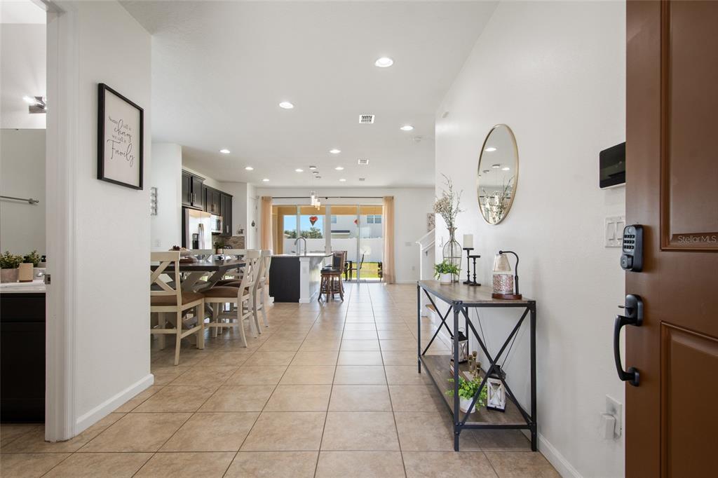 An entryway leads into an open-concept kitchen and living area with tile flooring throughout — 1659 GENTLE BREEZE DRIVE, ST CLOUD, FL