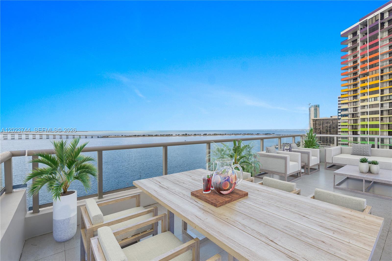 A spacious outdoor balcony features a dining table, lounge seating, and views of the water — 1541 Brickell Ave # C1607, Miami FL 33129, MIAMI, FL