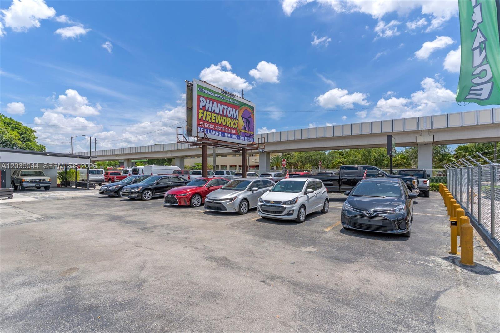 An outdoor parking lot features several parked cars beneath a large Phantom Fireworks billboard — 2729 NW 56th St, Miami FL 33142, MIAMI, FL