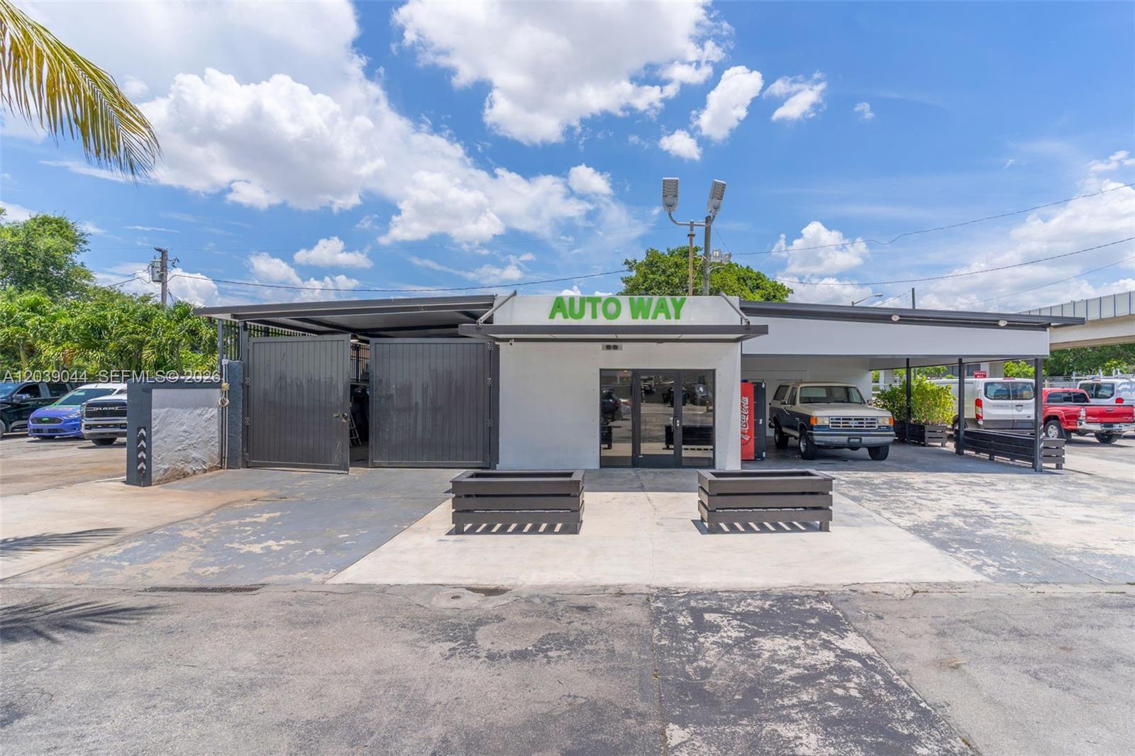 The exterior of a commercial auto shop features a white building with a metal awning — 2729 NW 56th St, Miami FL 33142, MIAMI, FL
