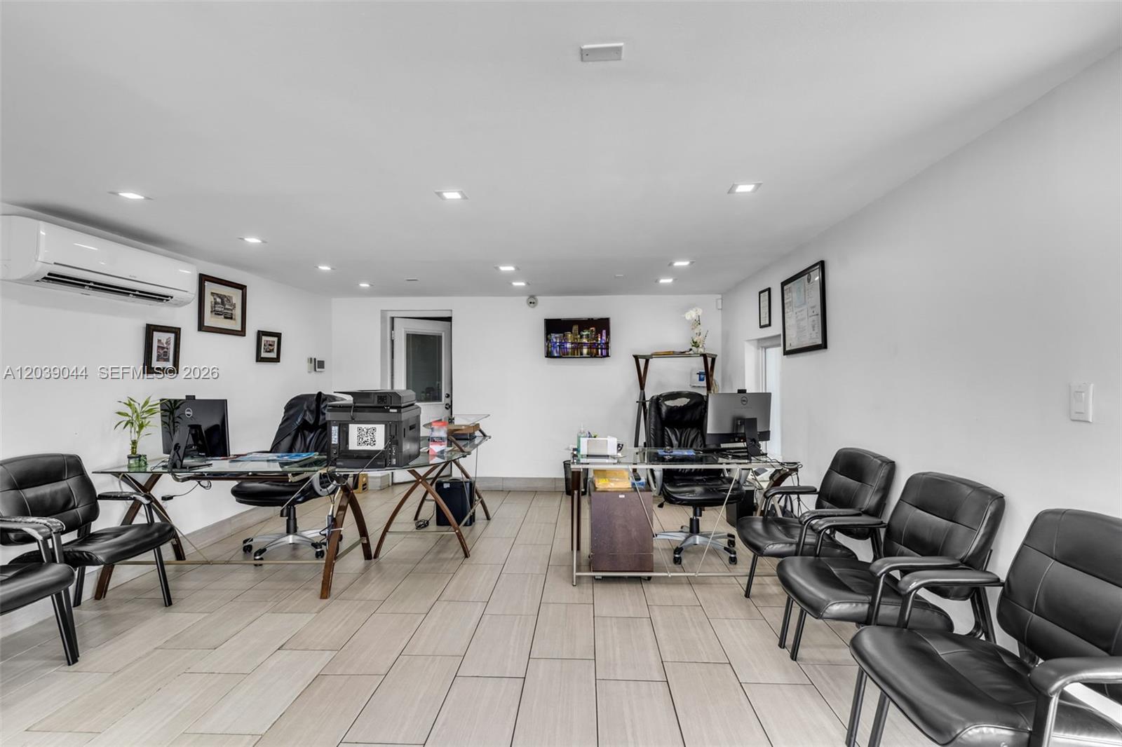 An office space features two glass desks, black leather chairs, and light-colored tile flooring — 2729 NW 56th St, Miami FL 33142, MIAMI, FL