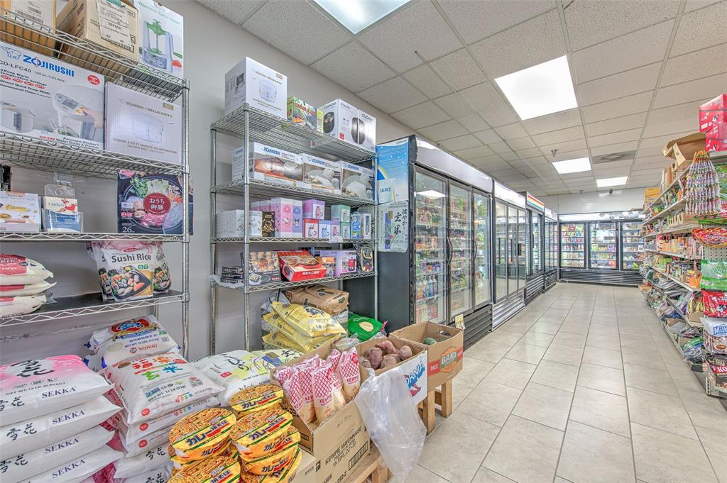 An interior view of a grocery store aisle featuring metal shelving units and refrigerated display cases — 5537 SHELDON ROAD UNIT V, TAMPA, FL