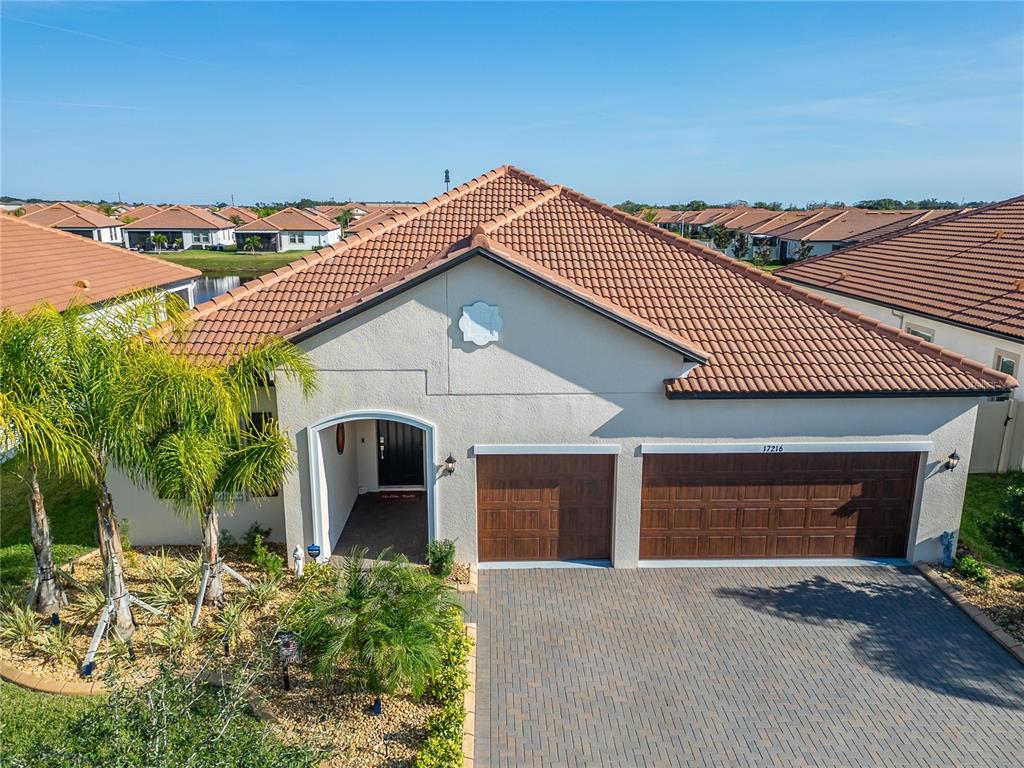 A single-story house features a tiled roof, a two-car garage, and a landscaped front yard — 17216 SCUBA CREST STREET, WIMAUMA, FL