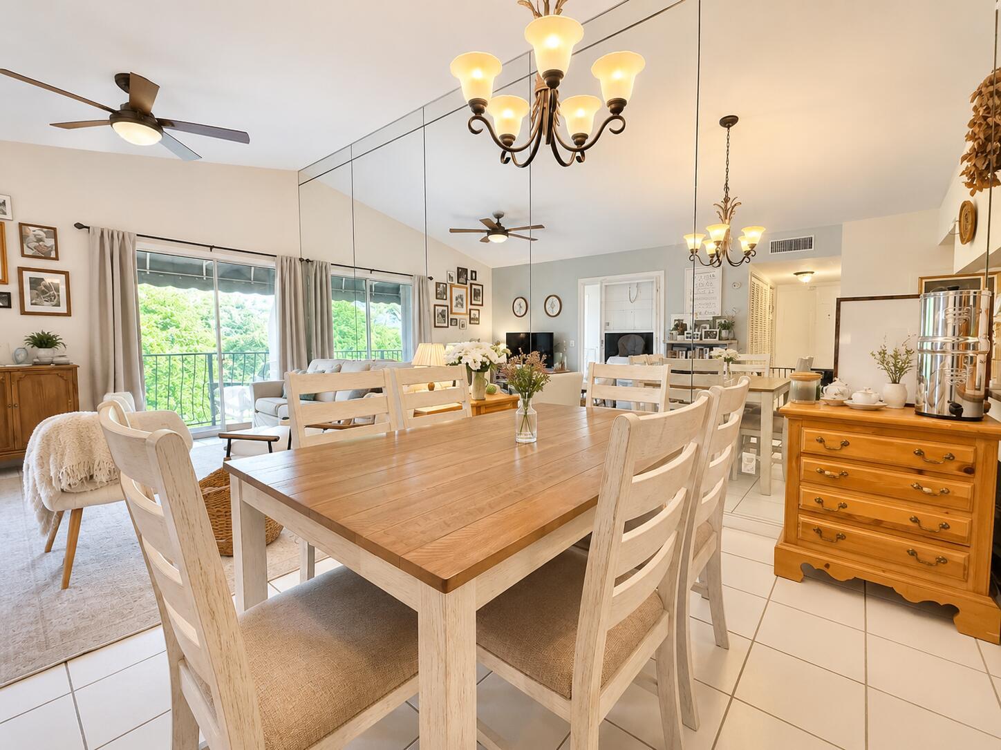 A dining room features a wooden table, white chairs, tiled floors, and a mirrored wall — 179 Waterside Drive # 179, Hypoluxo FL 33462, HYPOLUXO, FL