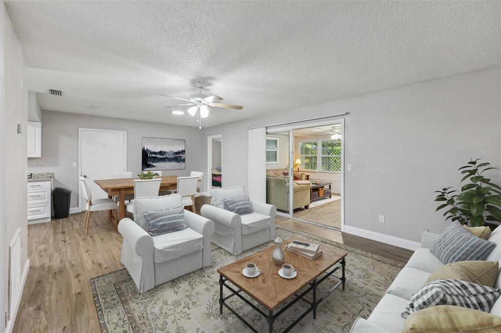 A living room and dining area feature light gray walls, wood-look flooring, and a ceiling fan — 3 SILVER COURT, OCALA, FL