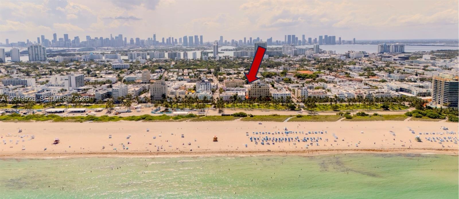 An aerial view shows a beach, palm trees, and city buildings with a red arrow — 1300 Collins NE St, Miami FL 33139, MIAMI, FL