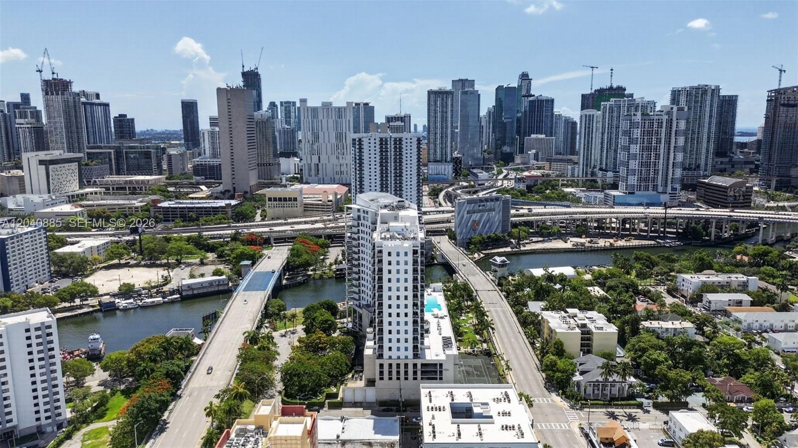 An aerial view of a dense urban skyline featuring high-rise buildings, bridges, and a river — 10 SW South River Dr # 1005, Miami FL 33130, MIAMI, FL