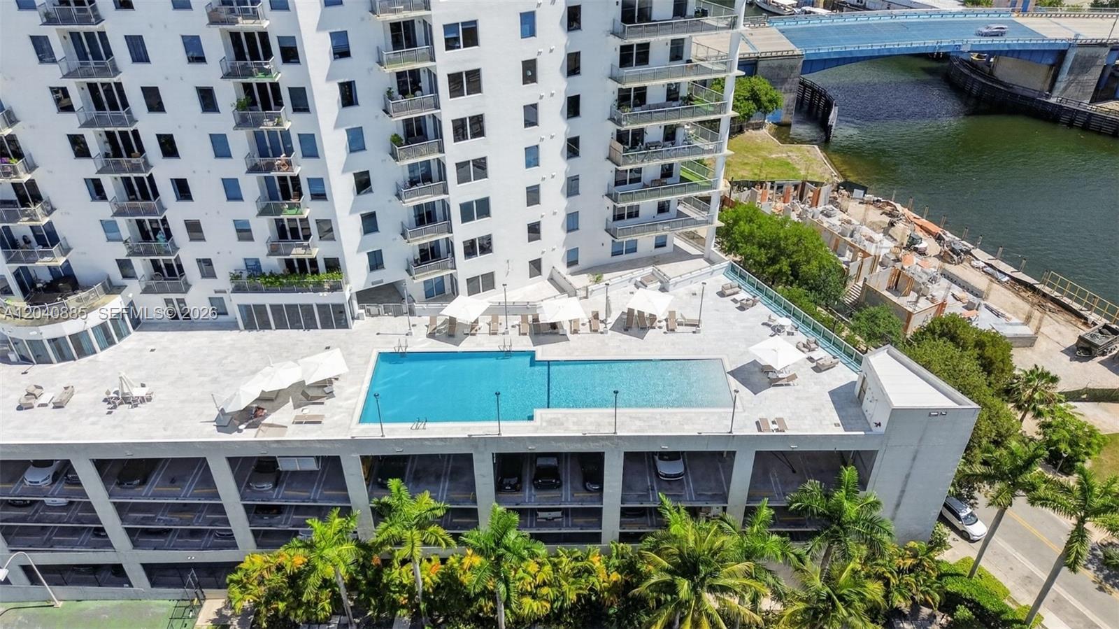 An aerial view shows a high-rise building with an outdoor pool deck and parking garage — 10 SW South River Dr # 1005, Miami FL 33130, MIAMI, FL