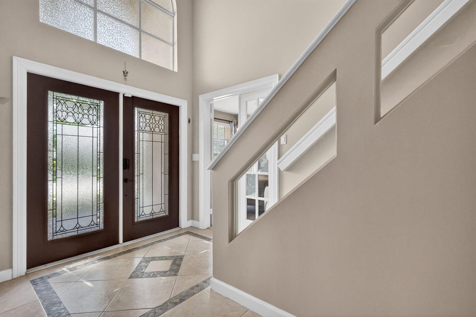 An entryway features a double front door with glass inserts, tile flooring, and a staircase — 3620 Hamilton Key, West Palm Beach FL 33411, WEST PALM BEACH, FL