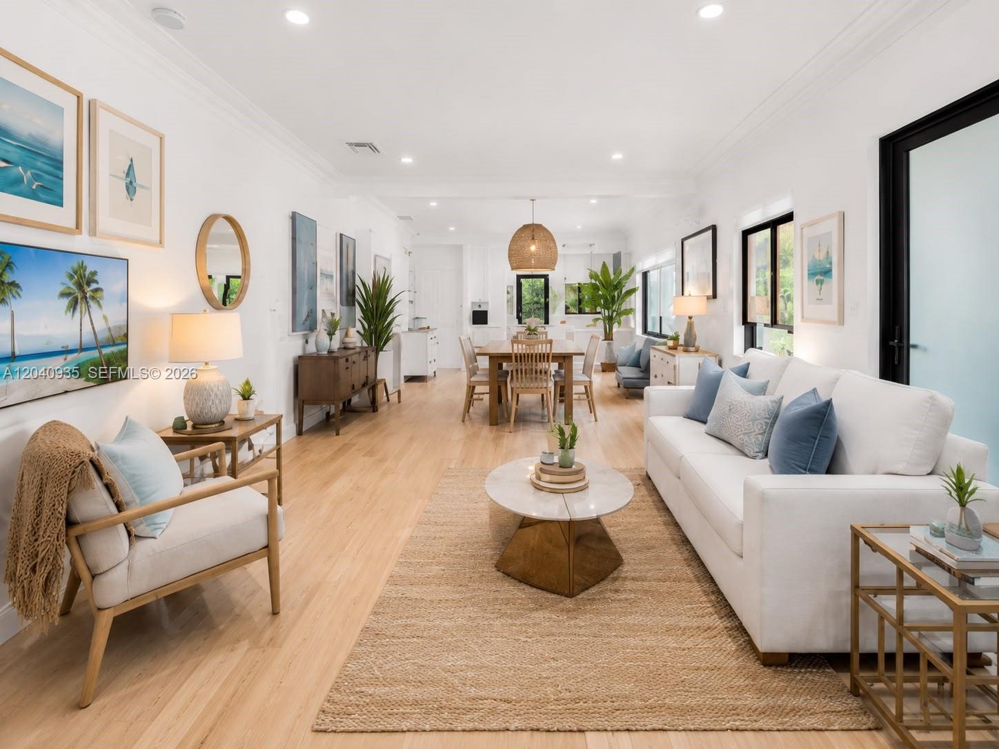 A bright, open-concept living and dining area features white walls, light wood floors, and modern furnishings — 375 SW 32nd Rd, Miami FL 33129, MIAMI, FL