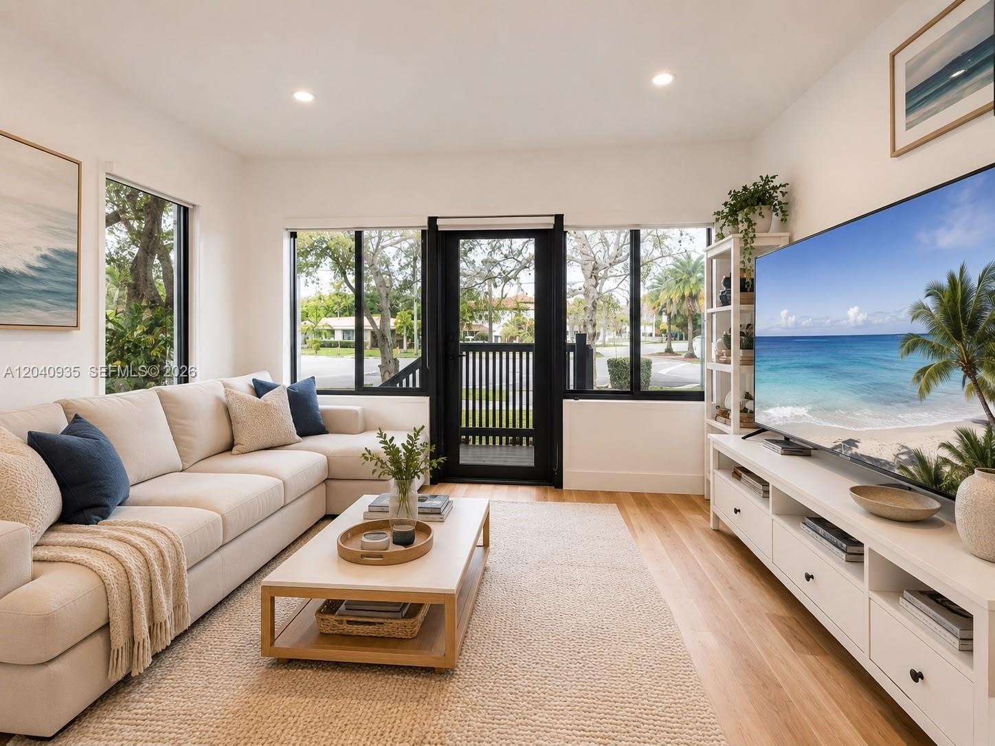 A bright living room features a beige sectional sofa, a coffee table, and a television — 375 SW 32nd Rd, Miami FL 33129, MIAMI, FL