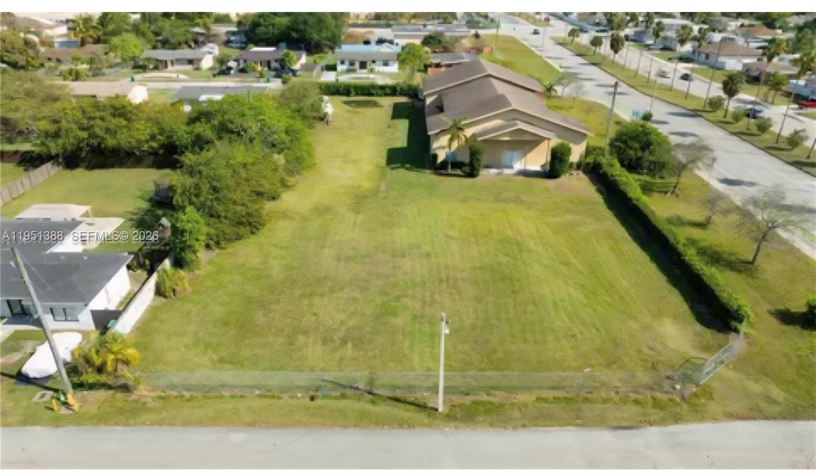 An aerial view shows a large, vacant grassy lot next to a single-story house — 21571 SW 110th Ave, Miami FL 33189, MIAMI, FL