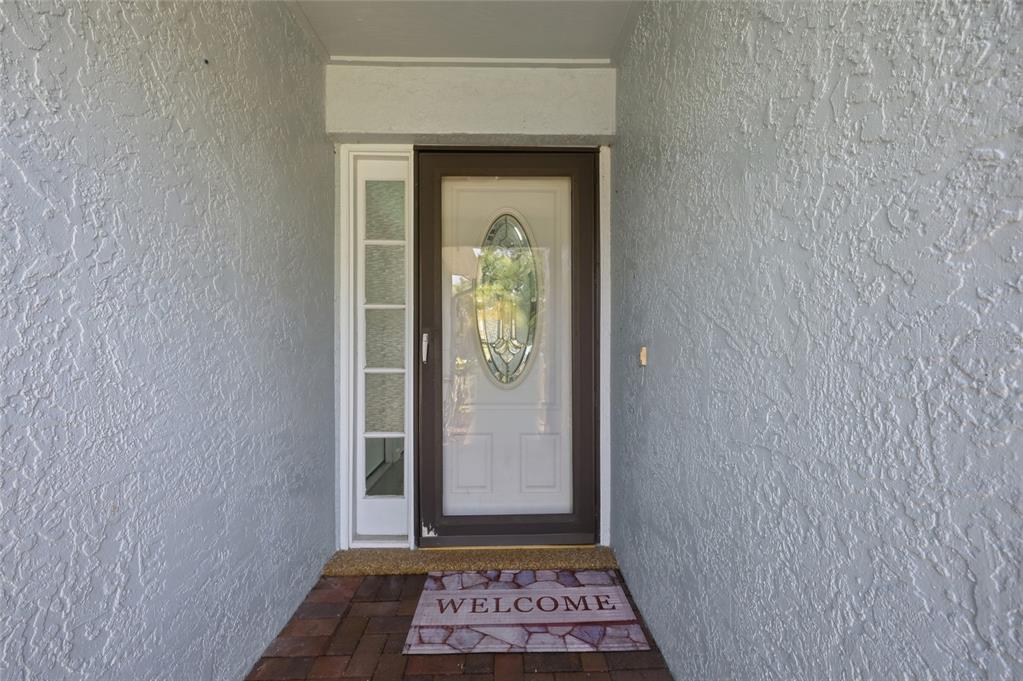 A front entryway features a white door with an oval glass insert and a sidelight — 1014 CONLEY DRIVE, OVIEDO, FL