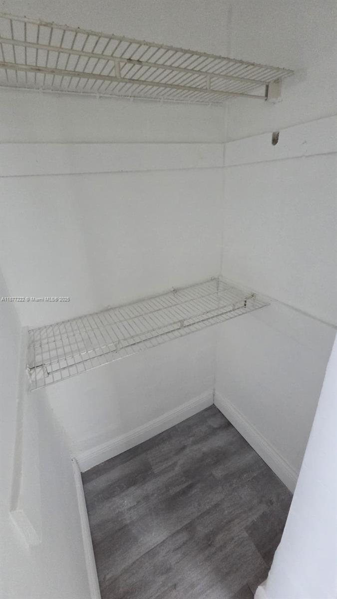 A small closet features white walls, gray wood-look flooring, and two wire shelves — 855 NW 3rd Ter # 6, Dania Beach FL 33004, DANIA BEACH, FL