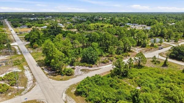 An aerial view shows a vacant, tree-covered corner lot at the intersection of two paved roads — 911 Sterling, Lehigh Acres FL 33974, LEHIGH ACRES, FL