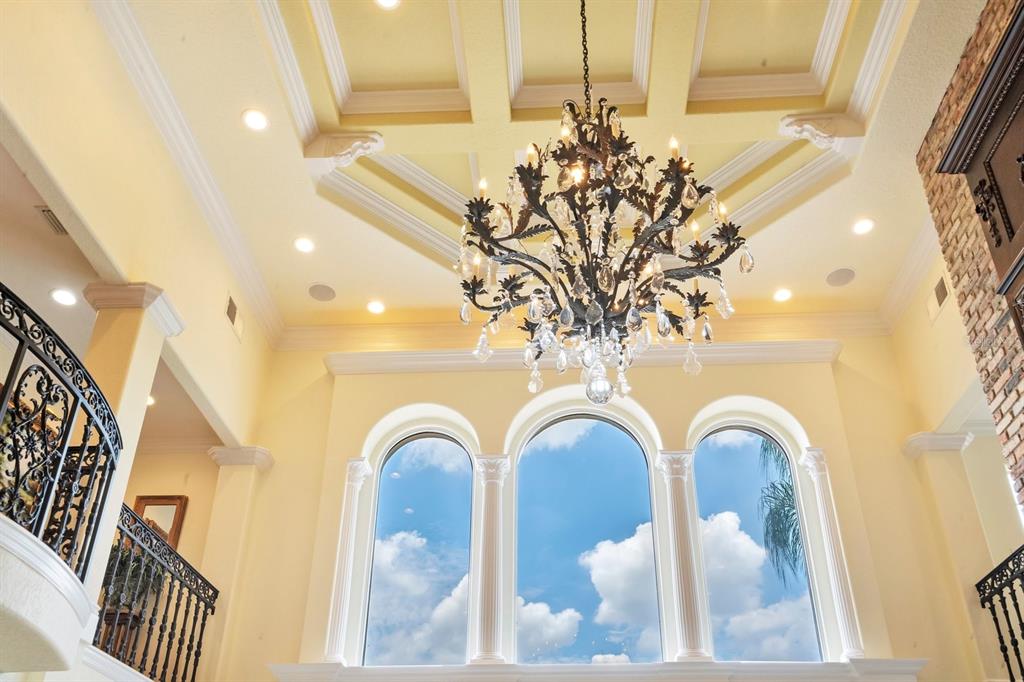 A grand foyer features a coffered ceiling, a large crystal chandelier, and arched windows — 133 VAN FLEET COURT, AUBURNDALE, FL