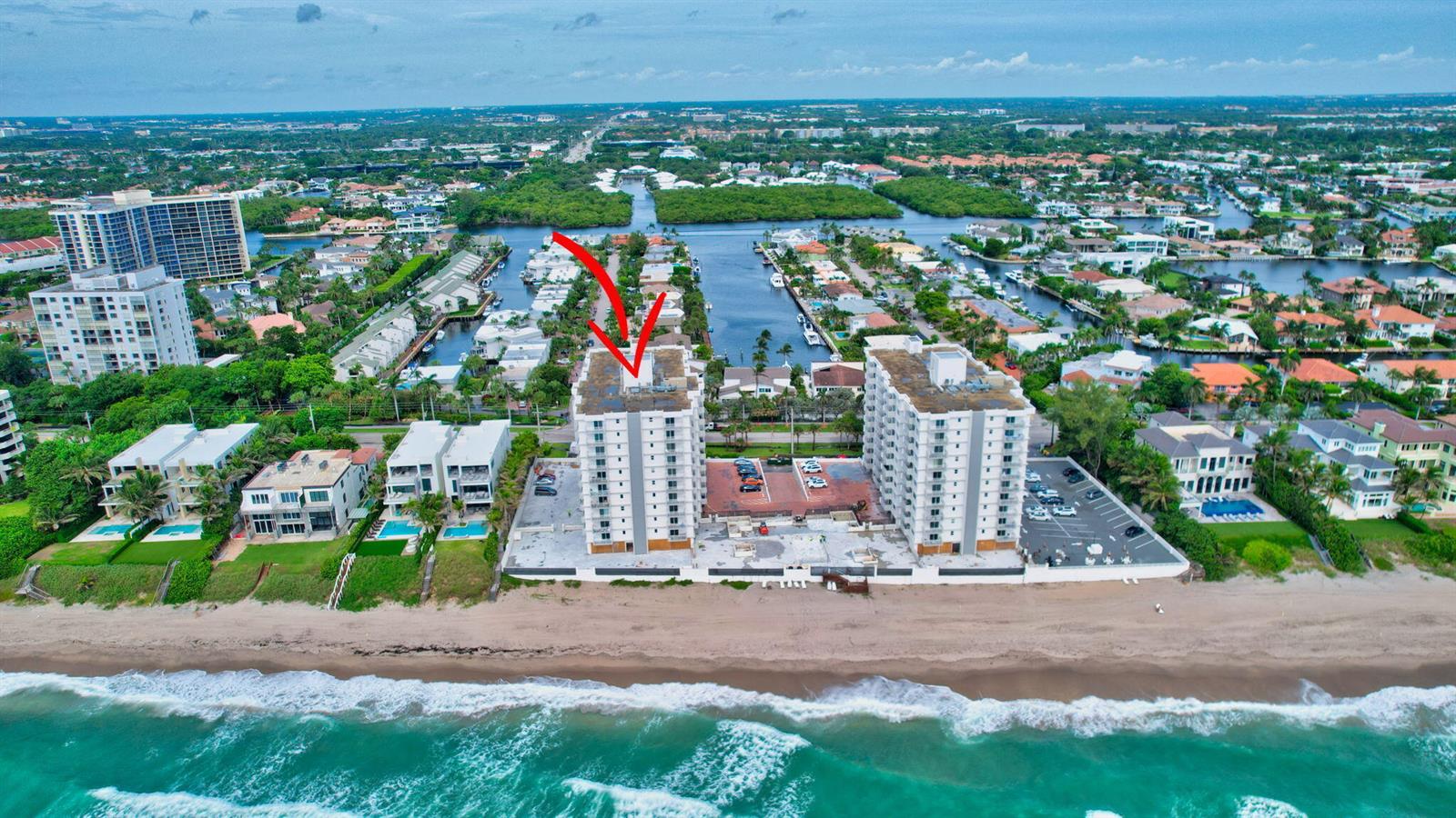 An aerial view of two beachfront condominium buildings with a red arrow pointing toward one — 4511 S Ocean Boulevard # 401, Highland Beach FL 33487, HIGHLAND BEACH, FL