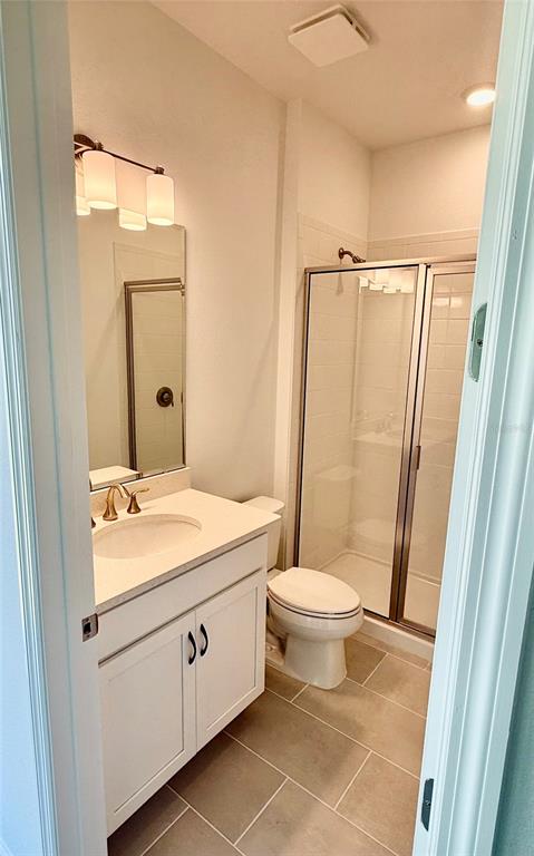 A modern kitchen features white cabinets, a large island, stainless steel appliances, and tile flooring — 2680 CAVANAUGH DRIVE, ORLANDO, FL