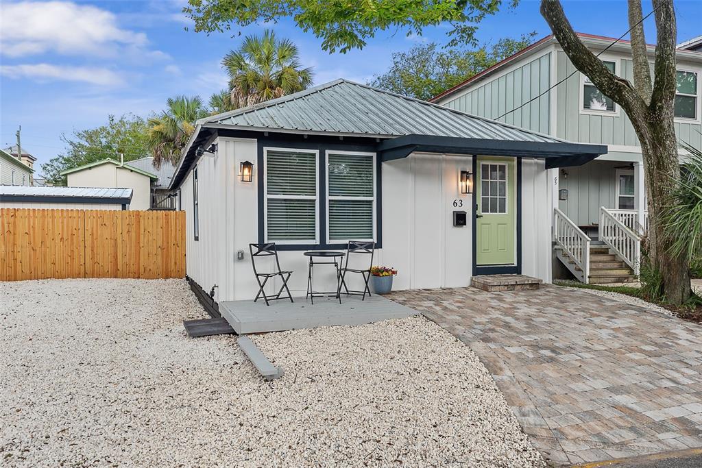 A small white house with a metal roof, a front porch, and a gravel yard — 63 ONEIDA STREET, ST AUGUSTINE, FL