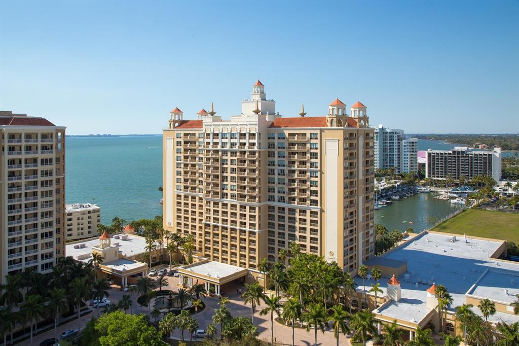 An aerial view of a large, tan multi-story hotel building situated near a bay — 1111 RITZ CARLTON DRIVE UNIT 1803, SARASOTA, FL