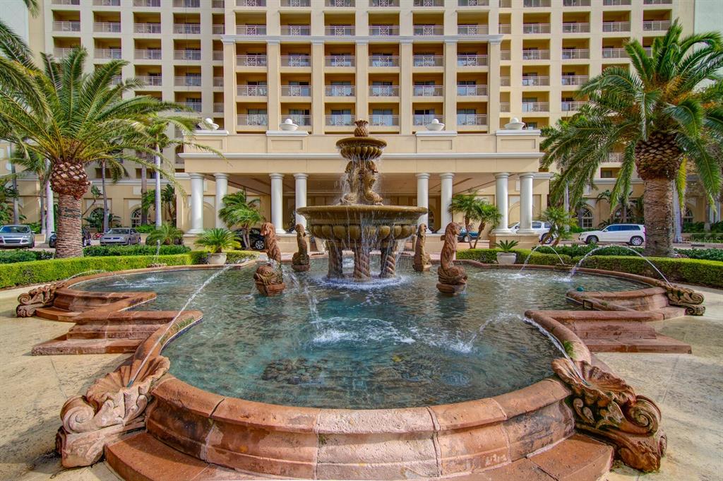 A large tiered stone fountain sits in front of a multi-story hotel with palm trees — 1111 RITZ CARLTON DRIVE UNIT 1803, SARASOTA, FL