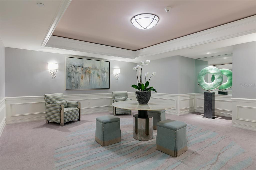A sitting area features a round table, four stools, two armchairs, and a large sculpture — 1111 RITZ CARLTON DRIVE UNIT 1803, SARASOTA, FL