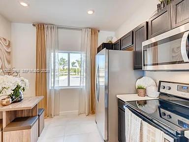 A kitchen features stainless steel appliances, dark wood cabinets, and an adjacent dining area — MIAMI GARDENS, FL
