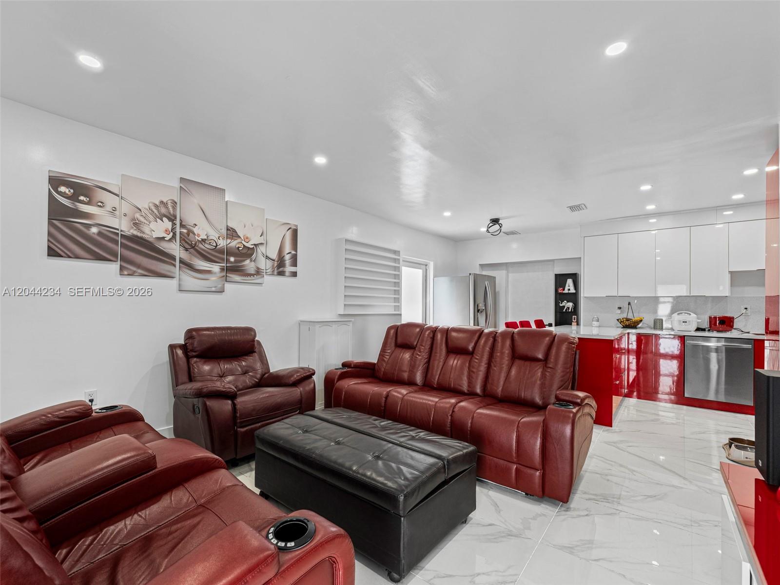 A living room with red leather furniture and a kitchen with white and red cabinets — 1215 Kasim ST, Opa-Locka FL 33054, OPA-LOCKA, FL