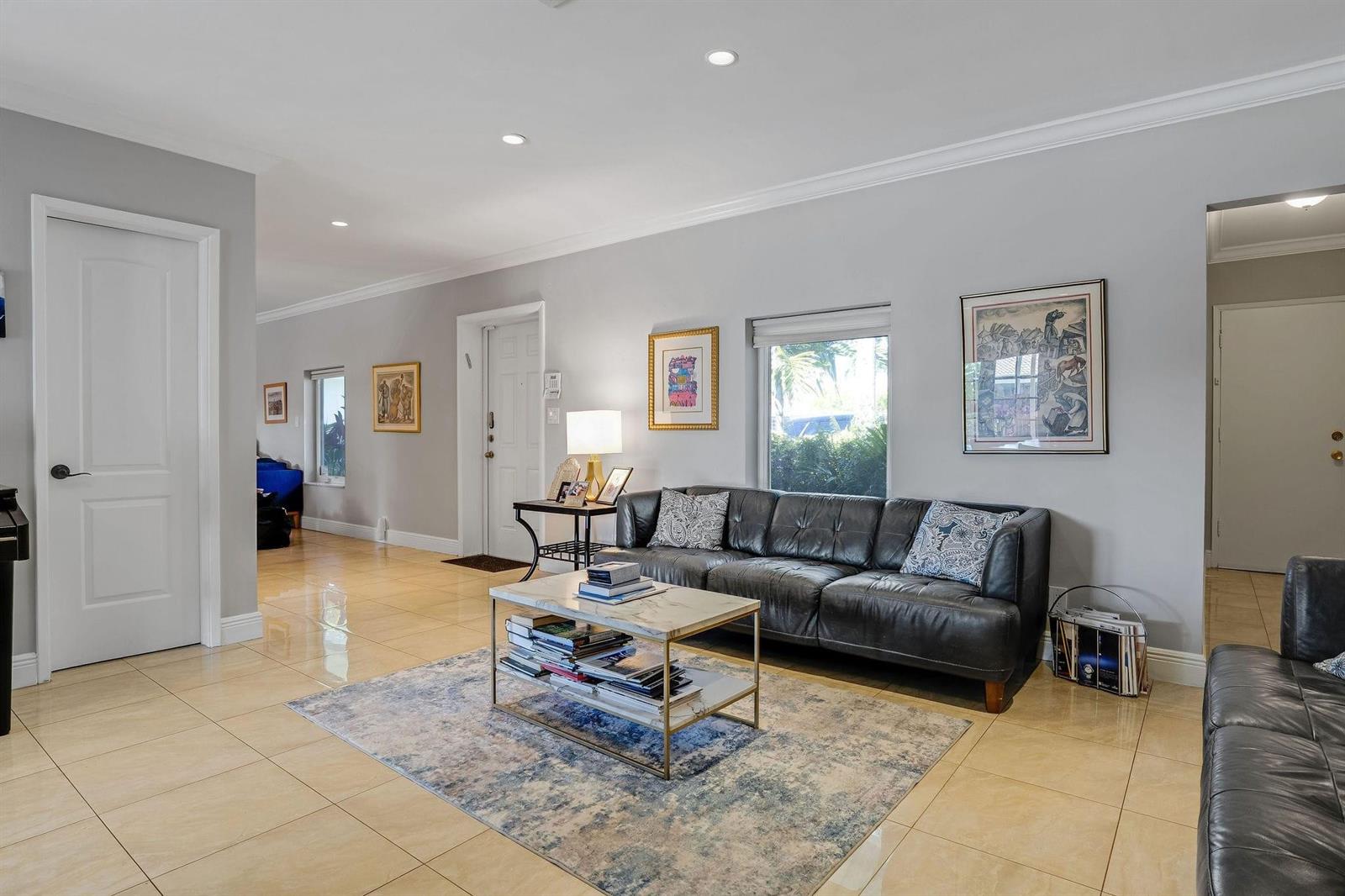 A living room features a dark leather sofa, marble coffee table, and light tile flooring — 4000 N 36th Avenue, Hollywood FL 33021, HOLLYWOOD, FL